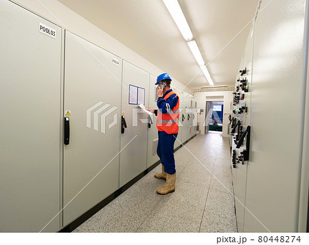Industrial engineer using phone in machin control room Industrial engineer using phone in machin control room 80448274