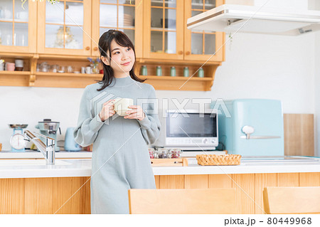 部屋で飲み物を飲む女性 部屋で飲み物を飲む女性 80449968
