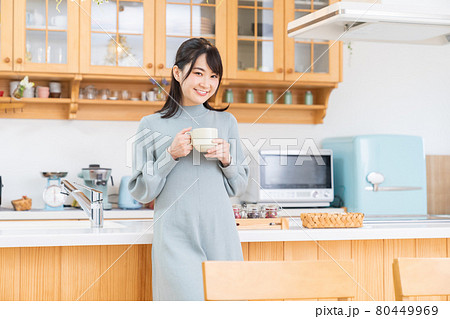 部屋で飲み物を飲む女性 部屋で飲み物を飲む女性 80449969
