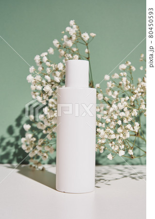 Natural cosmetic cream bottle on green background with plant 80450593