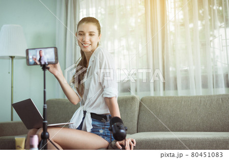 Beautiful woman blogger showing and demonstration cosmetic product on mobile phone camera screen at home 80451083