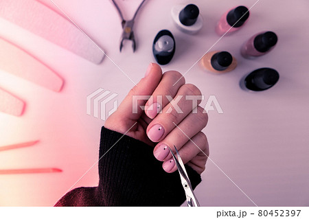 Woman hands, nail polish, manicure tools table top view flat lay. How to do manicure at home concept. Do manicure by yourself staying at home. Self care. Nude nails Woman hands, nail polish, manicure tools table top view flat lay. How to do manicure at home concept. Do manicure by yourself staying at home. Self care. Nude nails 80452397