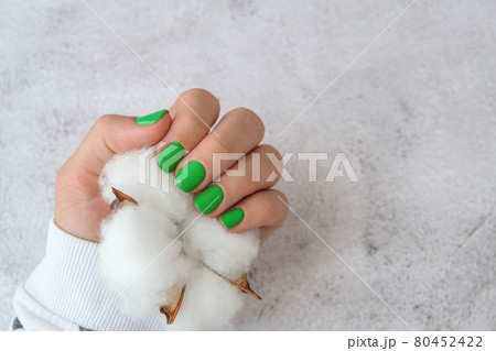 Manicured female hands with stylish green nails. Trendy modern design manicure. Gel nails. Skin care. Beauty treatment. Nail care. Trendy colors 80452422