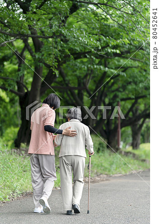公園で散歩するシニア女性と介護士　うしろ姿 80452641
