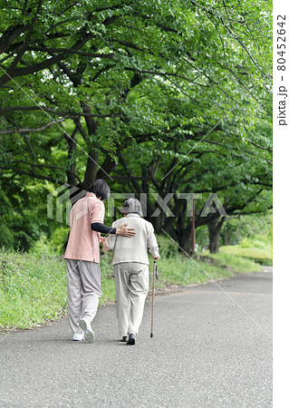 公園で散歩するシニア女性と介護士　うしろ姿 80452642