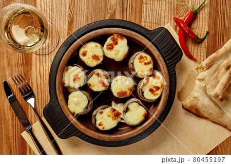 Baked mushrooms caps stuffed with sulguni in wooden bowl 80455197