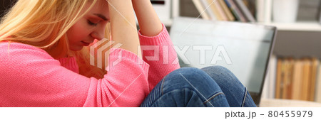 Unhappy lonely depressed woman sitting on the couch Unhappy lonely depressed woman sitting on the couch 80455979