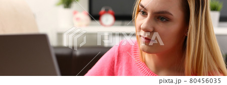 young beautiful blond woman sit in livingroom work on laptop young beautiful blond woman sit in livingroom work on laptop 80456035