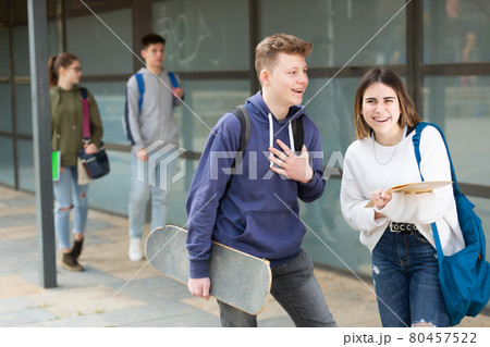 Two students discuss past lessons at college on the street 80457522