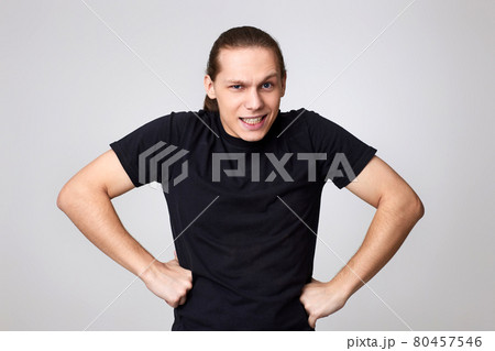 angry man in black t-shirt isolated on gray background 80457546