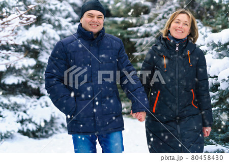 couple walking in a winter forest, two adult people, man and woman, beautiful nature with bright snowy fir trees couple walking in a winter forest, two adult people, man and woman, beautiful nature with bright snowy fir trees 80458430