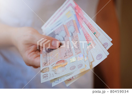New Plastic Ten and twenty Pound note sterling in woman hands. Crisis and saving concept. British finance sistem New Plastic Ten and twenty Pound note sterling in woman hands. Crisis and saving concept. British finance sistem 80459034