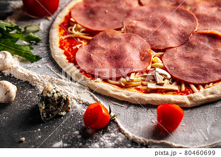 Prepared dough base for pizza with toppings 80460699