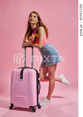 Tourist woman in summer casual clothes on pink background holding credit card. 80461588