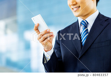 スマホを操作するビジネスマンの手元イメージ スマホを操作するビジネスマンの手元イメージ 80463357