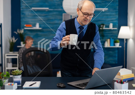 Retired businessman turning on laptop 80463542