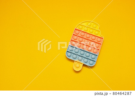 Rainbow antistress Pop it fidget toy on yellow background with copy space Rainbow antistress Pop it fidget toy on yellow background with copy space 80464287