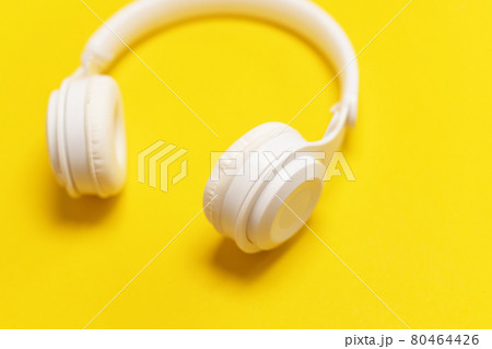 White wireless headphones on a yellow background 80464426