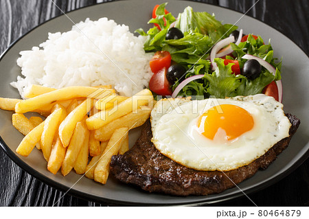 Beef Steak with Egg, french fries, rice and salad closeup in the plate. Horizontal 80464879