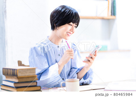 リビングで勉強中にスマホを使う若い女性 リビングで勉強中にスマホを使う若い女性 80465984