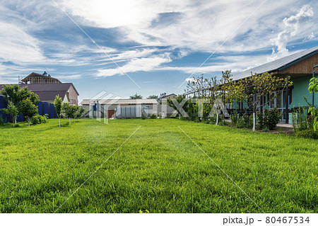 Outside of beautiful house and its garden with green lawn grass, pool and solar panels on the roof. 80467534
