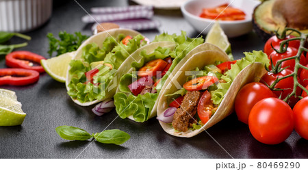 Mexican tacos with beef, tomatoes, avocado, onion and salsa sauce Mexican tacos with beef, tomatoes, avocado, onion and salsa sauce 80469290