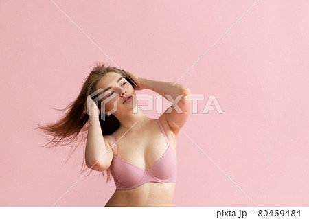 Adorable girl in lingerie posing isolated over pink studio background. Natural beauty, spa, cosmetics, fitness and aesthetic cosmetology concept. 80469484