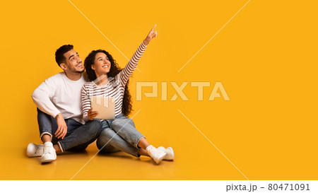 Nice Offer. Excited young arabic couple holding digital tablet and pointing away 80471091