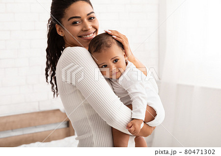 African American Mother Holding Her Baby Son Standing In Bedroom African American Mother Holding Her Baby Son Standing In Bedroom 80471302