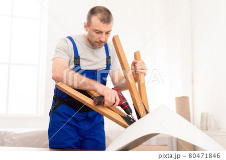 Professional Craftsman Carpenter Installing Table Using Electric Drill Indoors 80471846