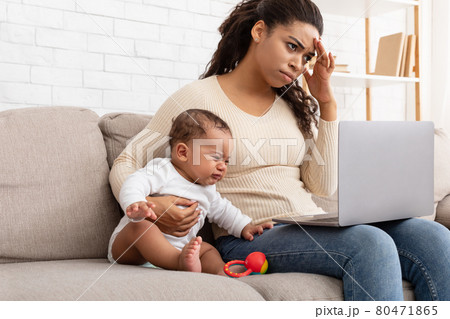 African Mother Trying Work On Computer While Infant Screaming Indoor African Mother Trying Work On Computer While Infant Screaming Indoor 80471865