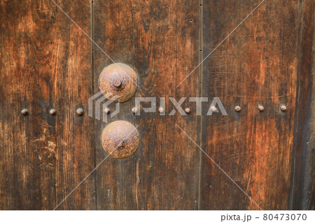 Rusted stake of ancient door lock on old wooden main castle door 80473070