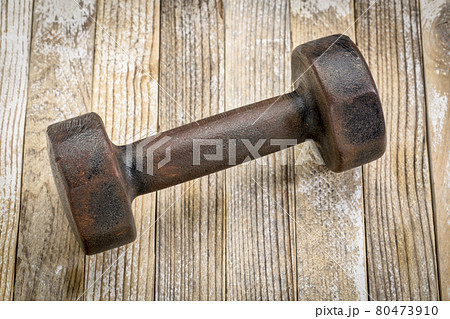 vintage iron dumbbell on wood 80473910