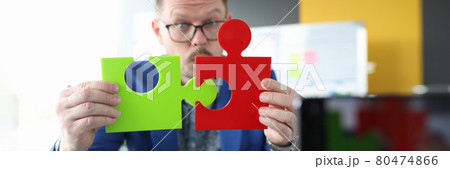 Male business blogger connects colorful puzzles closeup 80474866