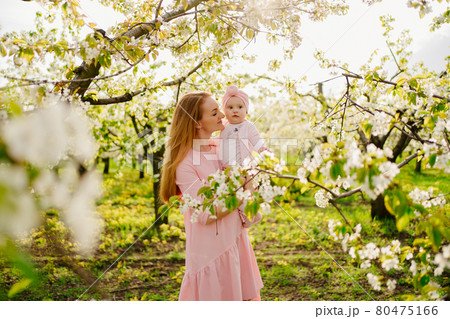 mother with baby in arms in flowering garden. surgery for child with cleft lip. mother with baby in arms in flowering garden. surgery for child with cleft lip. 80475166