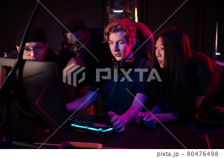 Players of the esports team gathered together in the computer club and watch the stream from the dota 2 world championship 80476498