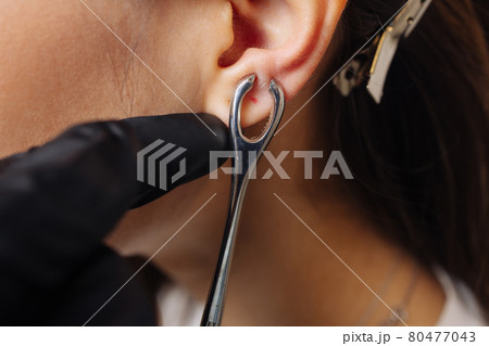 Professional holding the jewel of piercing just before screw the ball. Professional holding the jewel of piercing just before screw the ball. 80477043
