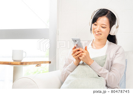 スマホで選曲する女性 80478745