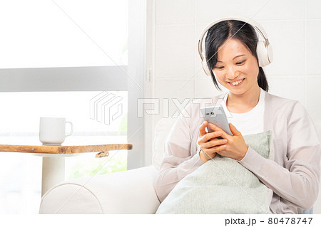 スマホで選曲する女性 80478747