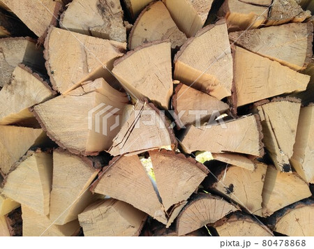 Chipped firewood is on the heap. Woodpile of firewood close-up. A stack of dry firewood, visible texture and cracks in the tree. Exterior shot of a large pile of firewood in soft daylight 80478868