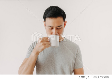 Man is drinking coffee or tea isolated on white background. 80479560