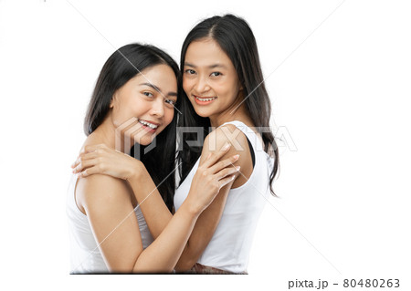 Two affectionate asian woman in a close embrace while smiling 80480263
