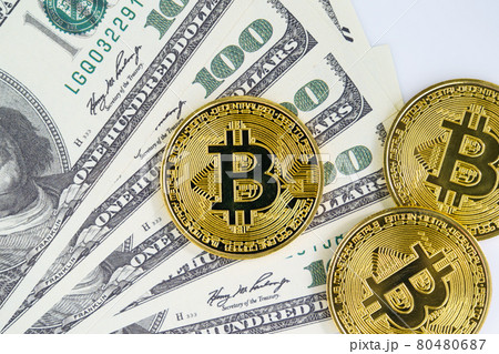 Bitcoins coin and banknotes of one hundred dollars Bitcoins coin and banknotes of one hundred dollars 80480687