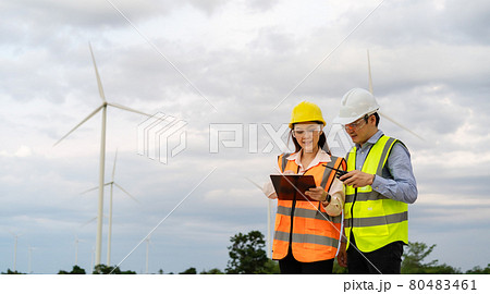 engineer team working with report in clipboard against wind turbine farm engineer team working with report in clipboard against wind turbine farm 80483461
