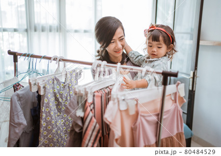 asian mother purchasing a clothes while shopping with her toddler baby asian mother purchasing a clothes while shopping with her toddler baby 80484529