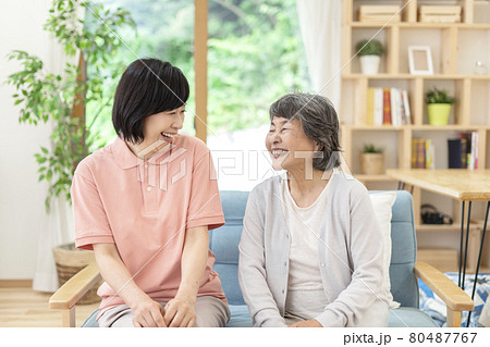 話をする女性介護士とシニア女性 80487767