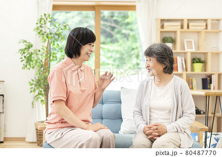 話をする女性介護士とシニア女性 80487770