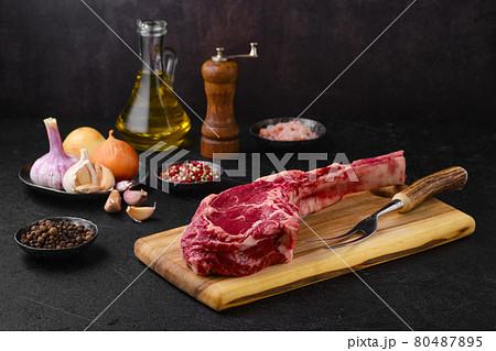 Raw beef cowboy steak with spice ready for cooking Raw beef cowboy steak with spice ready for cooking 80487895