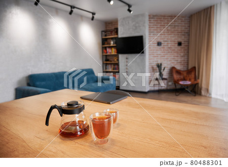Glass teapot and cups of tea on wooden table. 80488301