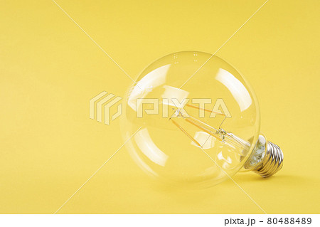 Transparent light bulb on yellow background 80488489